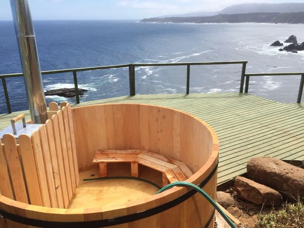 Tina de madera con calefactor sobre terraza frente al océano