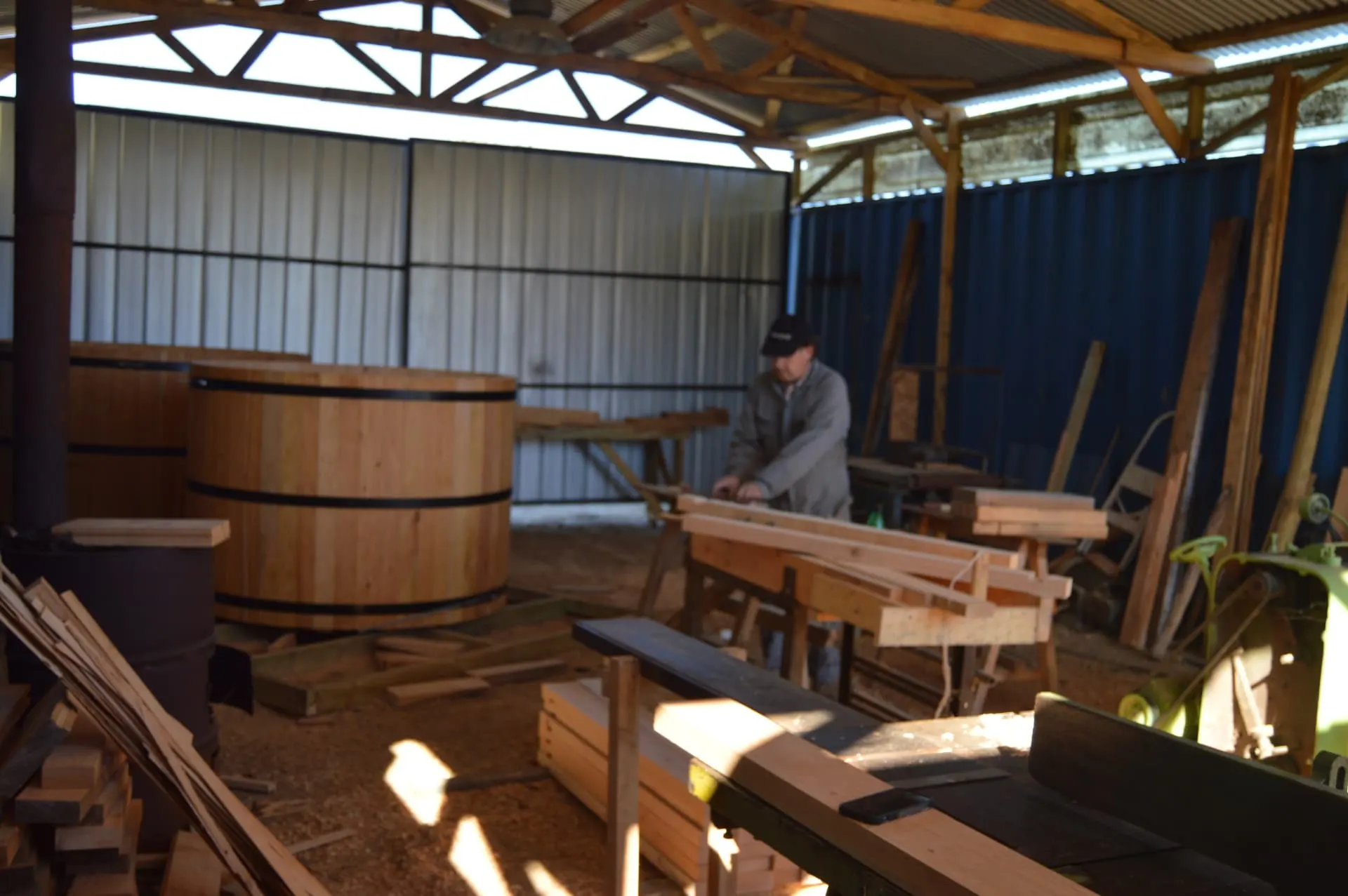 Artesano trabajando la madera en el taller de Hettich junto a tinas en fabricación